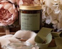 pink grapefruit and basil scented natural wax candle in amber jar with a gold lid